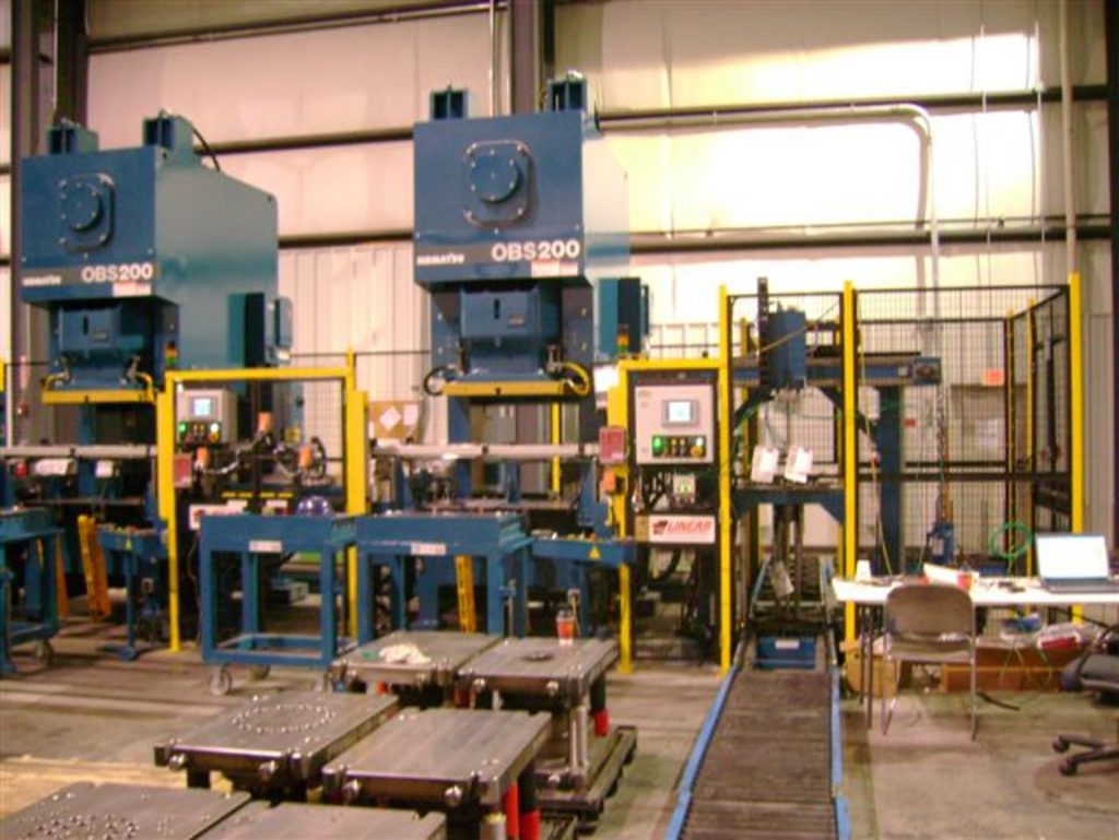 Two small, blue stamping presses outfitted with Linear Automation tandem line press systems.
