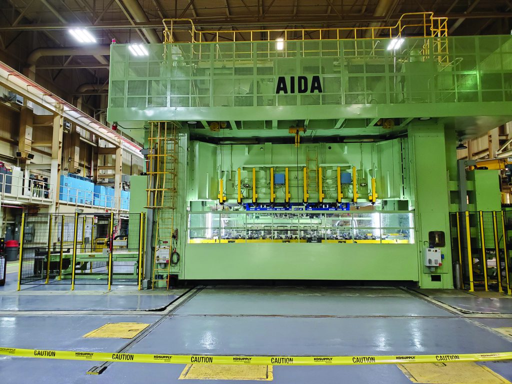 A large, green, AIDA press outfitted with Linear Automation transfer systems.