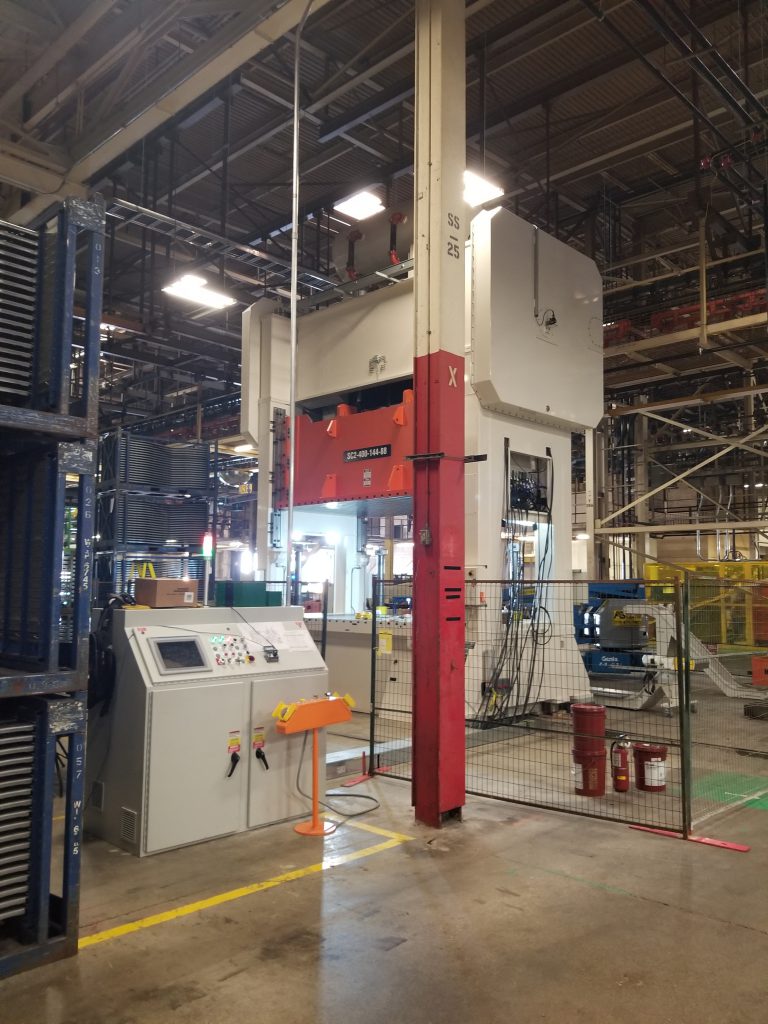 An image of a large metal stamping press, outfitted with Linear Automation press controls.