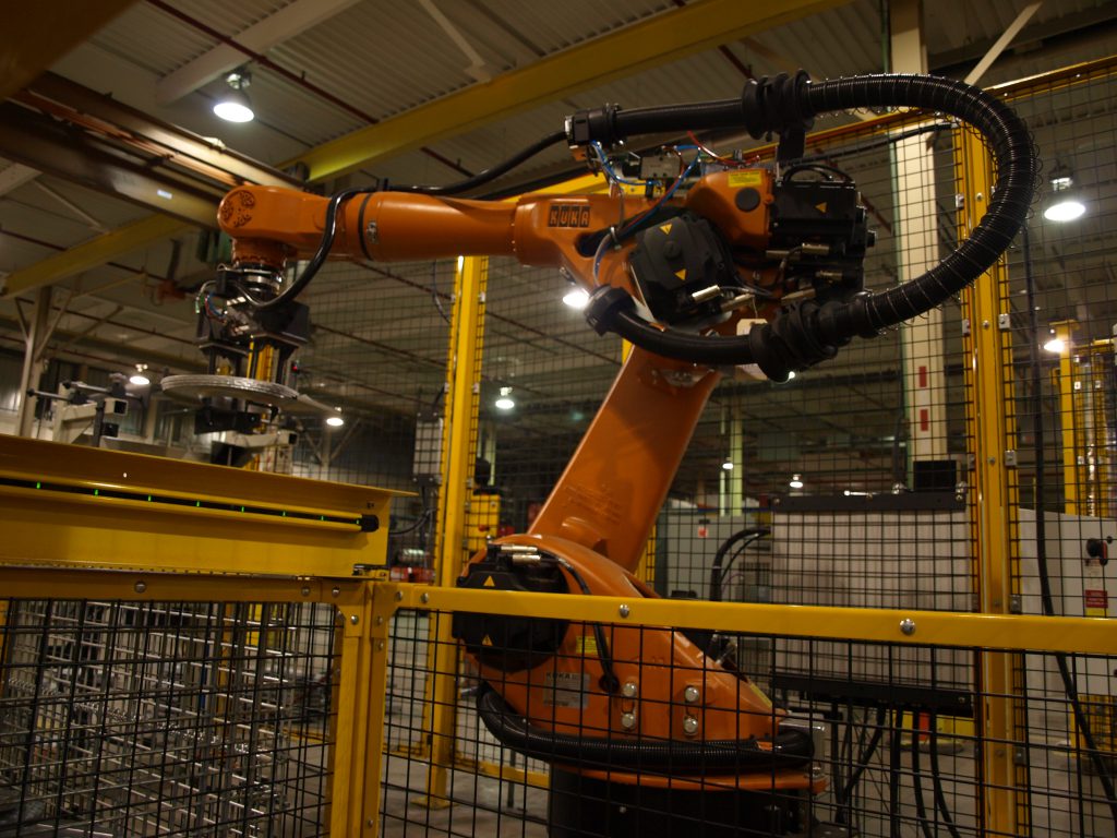 An image of a KUKA robot in a Linear Automation cell surrounded by safety fencing.